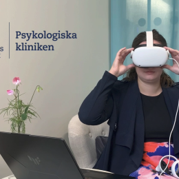 Kvinna med VR-glasögon fram en dator.