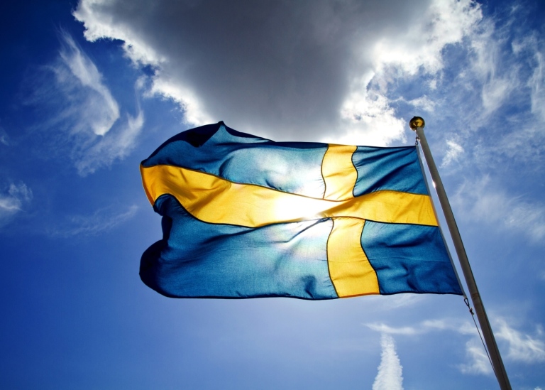 Svenska flaggan, skuggad av ett moln