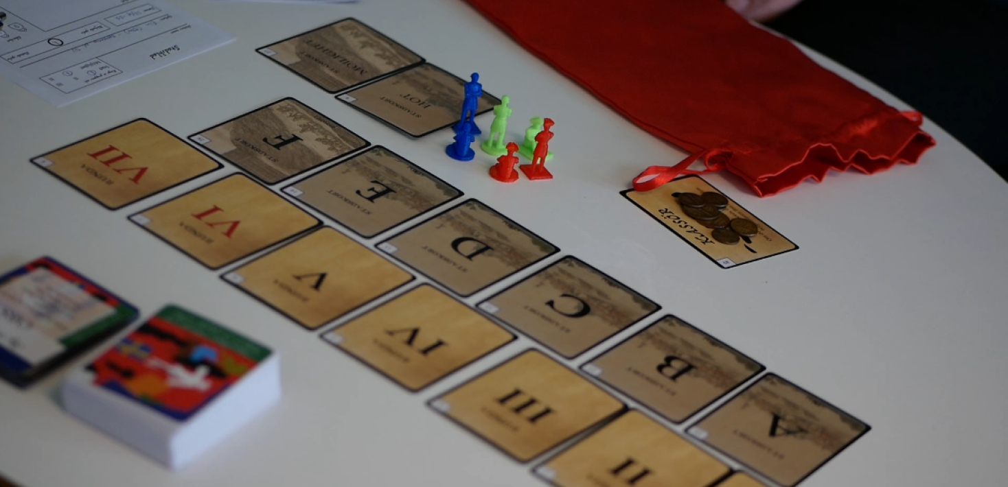 Spelkort och figurer upplagda på ett bord.