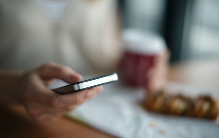 A hand holding a smartphone.