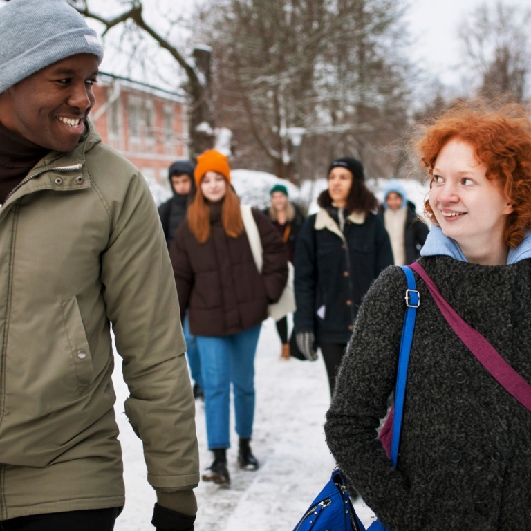A group of students walking on campus on a winter's day.