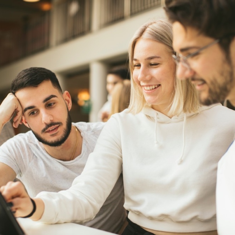 Three students looking at a lap top/ Photo: Niklas Björling/Stockholm University