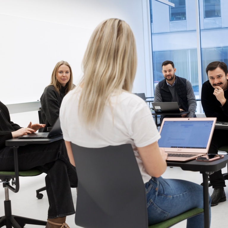 En grupp studenter vid en dator