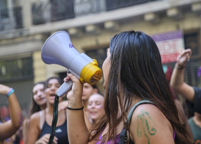Närbild på en kvinna i en grupp som håller i en megafon