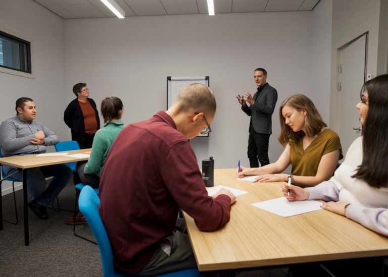 Studenter och pedagogiska konsulter i ett workshoprum.