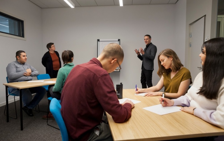 Studenter och pedagogiska konsulter i ett workshoprum.