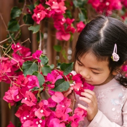 Flicka luktar på blommor. Foto: ADHD, RDNE Stock project from Pexels