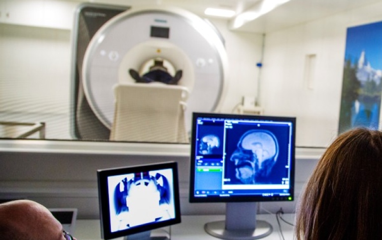 MRI-skanning och datorskärm med hjärna i genomskärning.