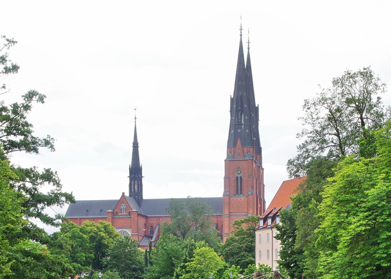 Uppsala domkyrka med törnet till höger, omgivet av grönska