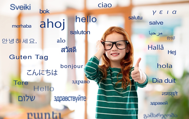 En barn med stora glasögon som hon håller i med ena handen. "Hej" på olika språk svävar runt henne. 