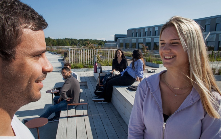 En manlig och en kvinnlig student på en av terrasserna på Campus Albano, Stockholms universitet