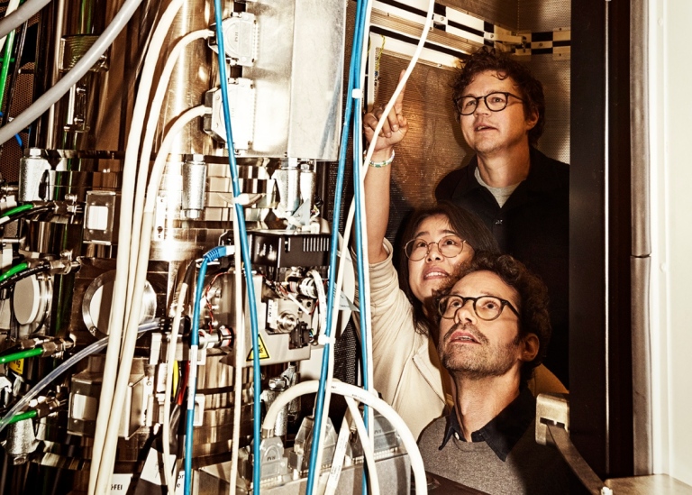 Tre forskare och studenter tittar på kablar.