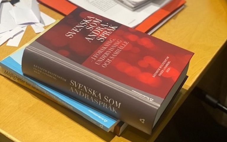 Visar en bokhög med boken Svenska som andraspråk överst