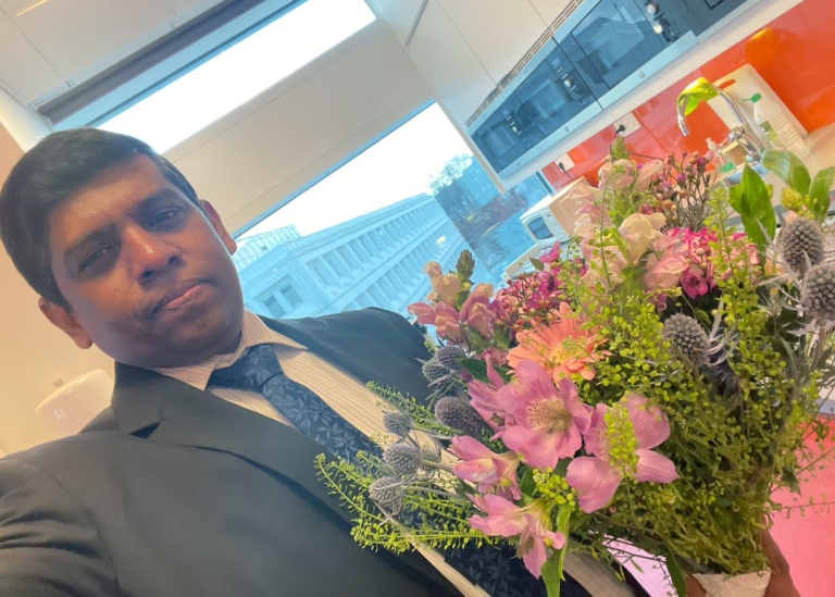 Selfie portrait of Sampath Deegalla with a bouquet of flowers..