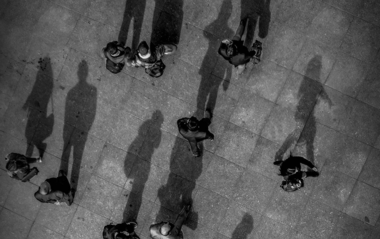 Aerial view of a square with people with long shadows. Photo: Gökhan Sirkeci from Pexels