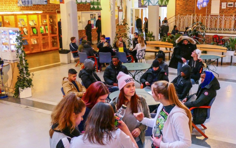 Interiörbild gymnasium med grupper av elever