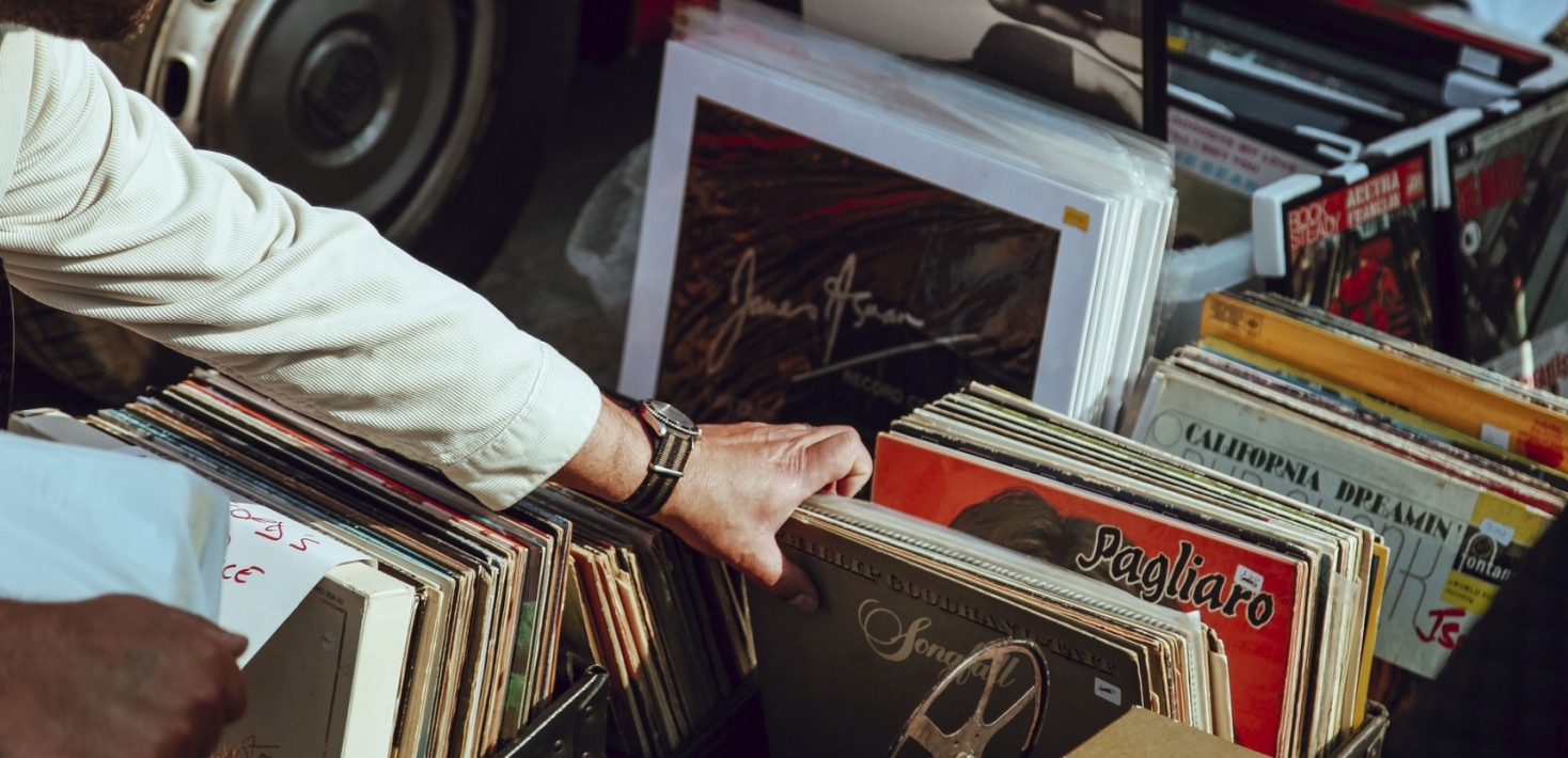 A hand shuffling through some Italian vinyl records