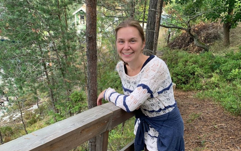 Yulia Kashevarova i skogen lutar sig mot ett trappräcke