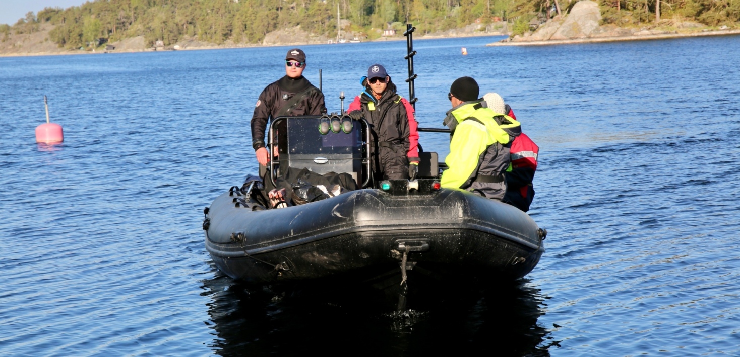 Forskningsteam i ribbåt närmar sig bryggan.