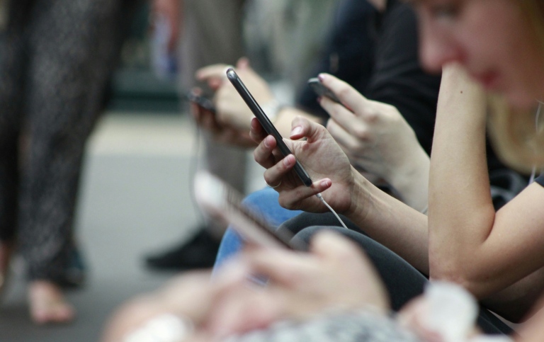 A group of people using their mobile phones.