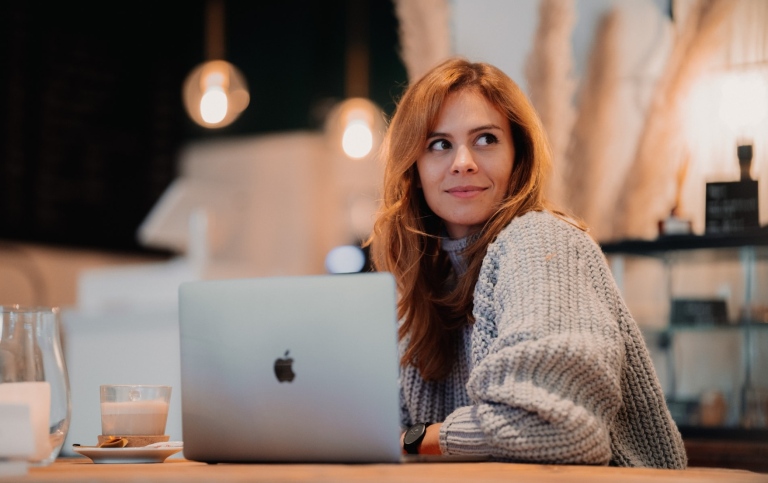 Leende kvinna vid laptop.