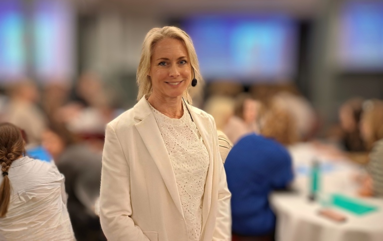 Helena Reierstam framför deltagare på en konferens