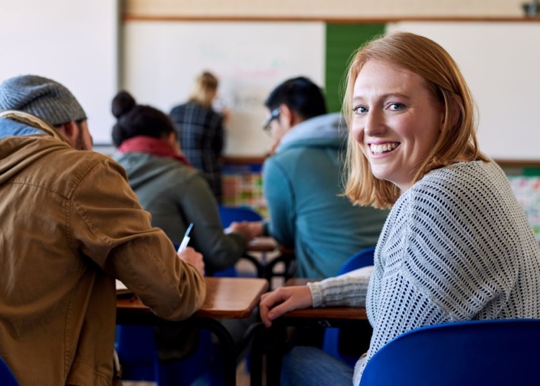 Happy female student lookin into the camera.