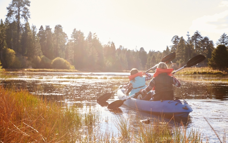people kayaking on lake, back view