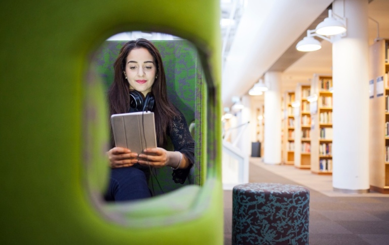 Woman reading on a tablet in the library