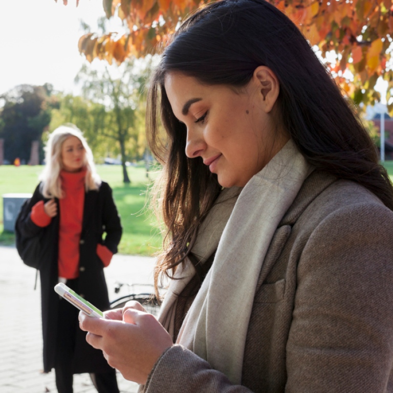 Kvinna som tittar i mobiltelefon