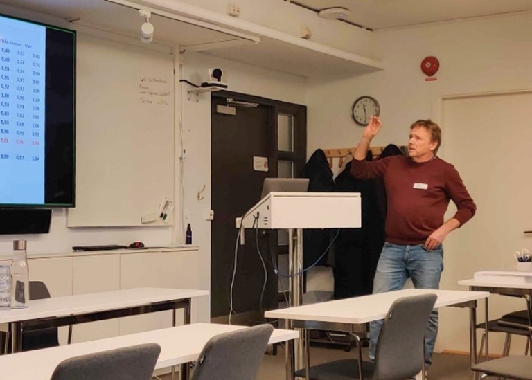 En man står och pekar på en whiteboard