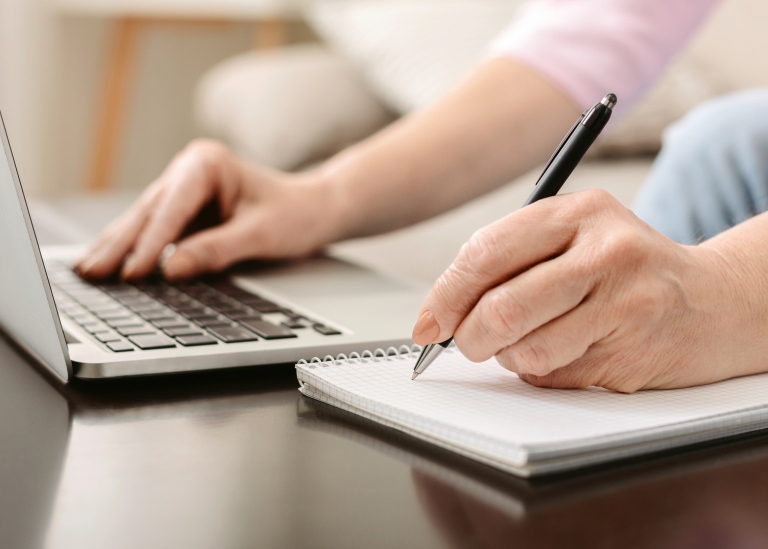 Kvinna som antecknar vid datorn.