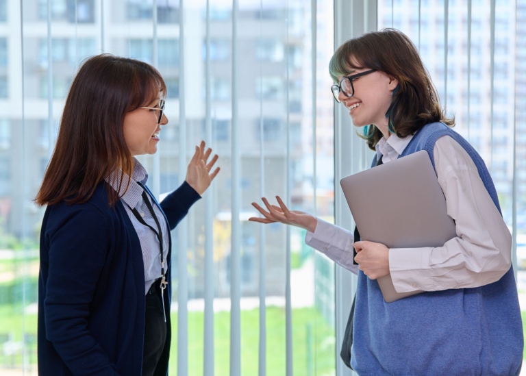 Kvinnlig lärare och student i samtal.