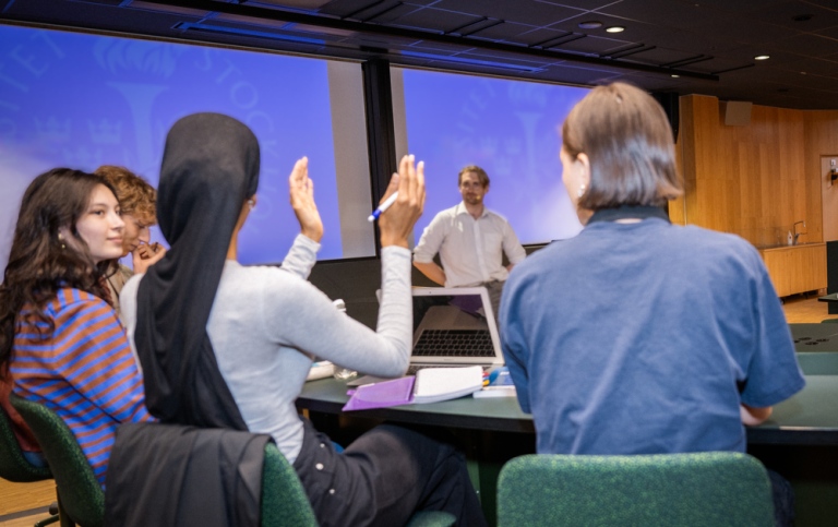 Fyra studenter sitter í ett modernt föreläsningsrum