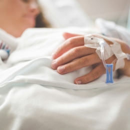 A sick person in a hospital bed.