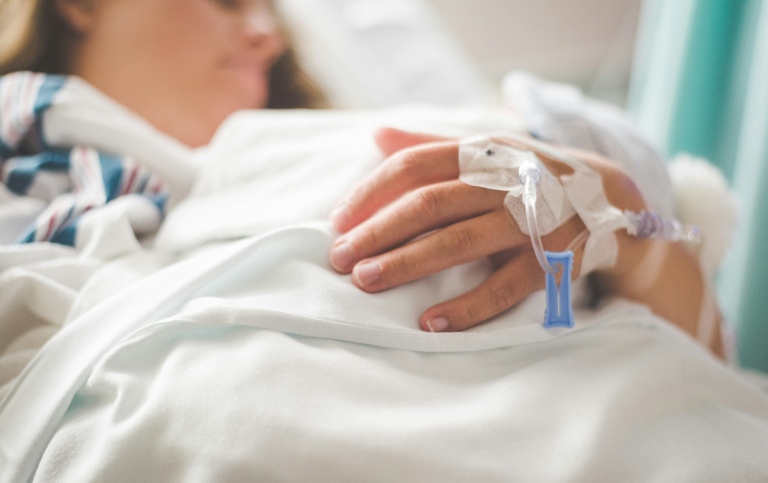 A sick person in a hospital bed.