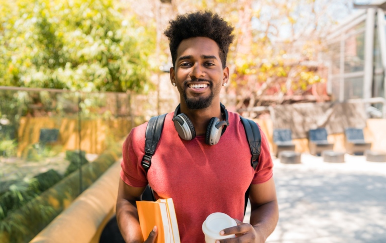 Happy student holding his books.