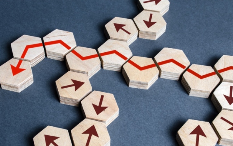 COver dissertation wooden game pieces with red and brown arrows.