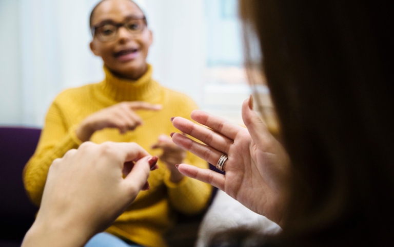 Två studenter sitter och tecknar, den ena personens händer syns litegrand snett bakifråm.