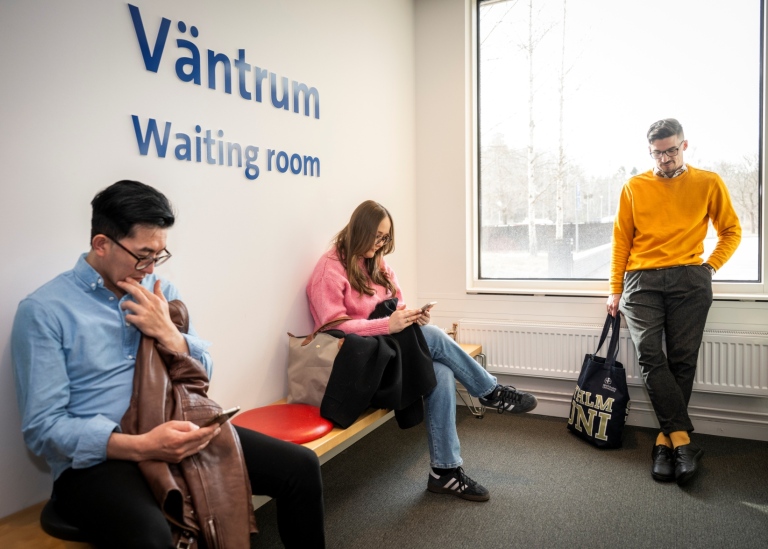 Three students in a waiting room at the university.