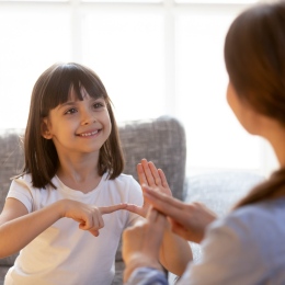 Girl practising sign language with teacher