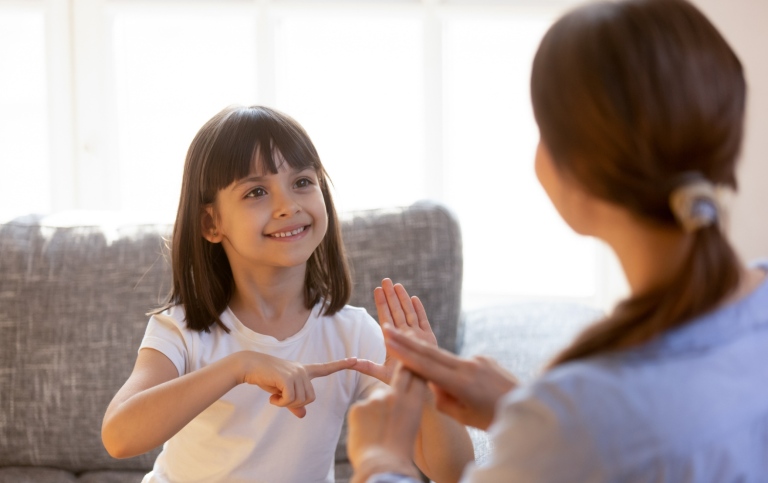 Girl practising sign language with teacher