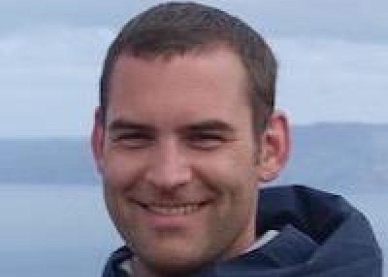 Fabien Roquet utomhus i jacka och blågrå himmel och moln i bakgrunden.