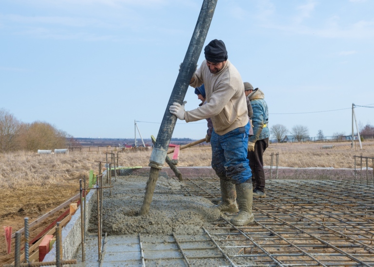 Migrant workers laying a foundation.
