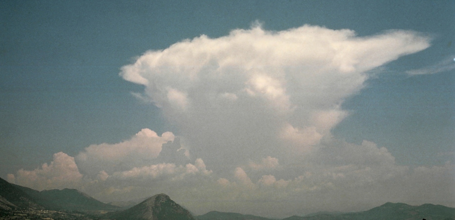 Cumulonimbus, städformat moln över berg.