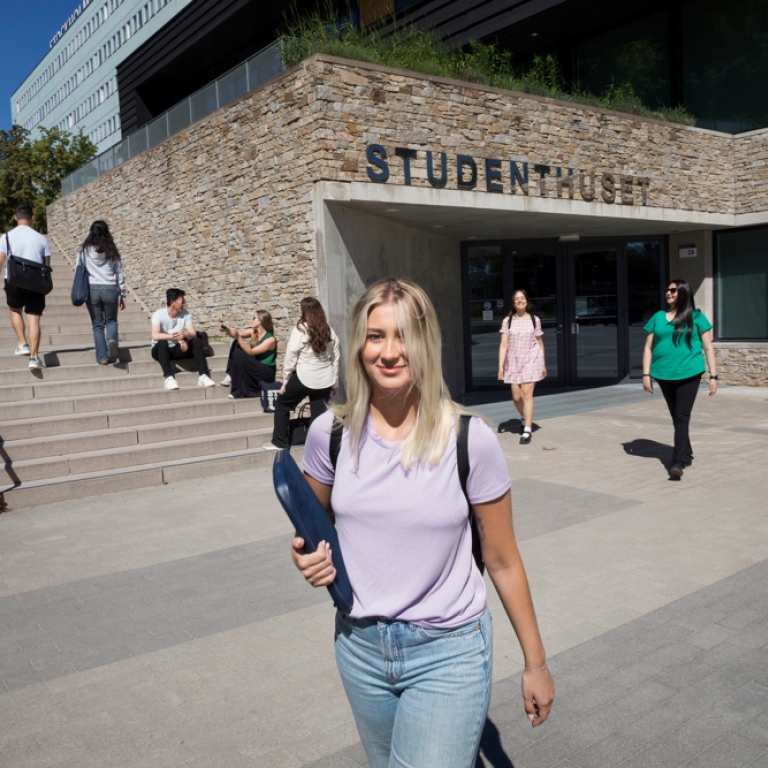 Students coming out of Studenthuset on a sunny day.