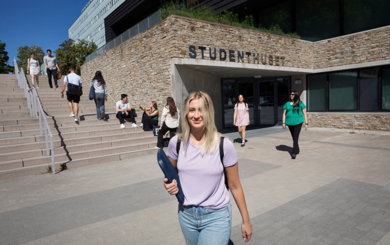 Students coming out of Studenthuset on a sunny day.