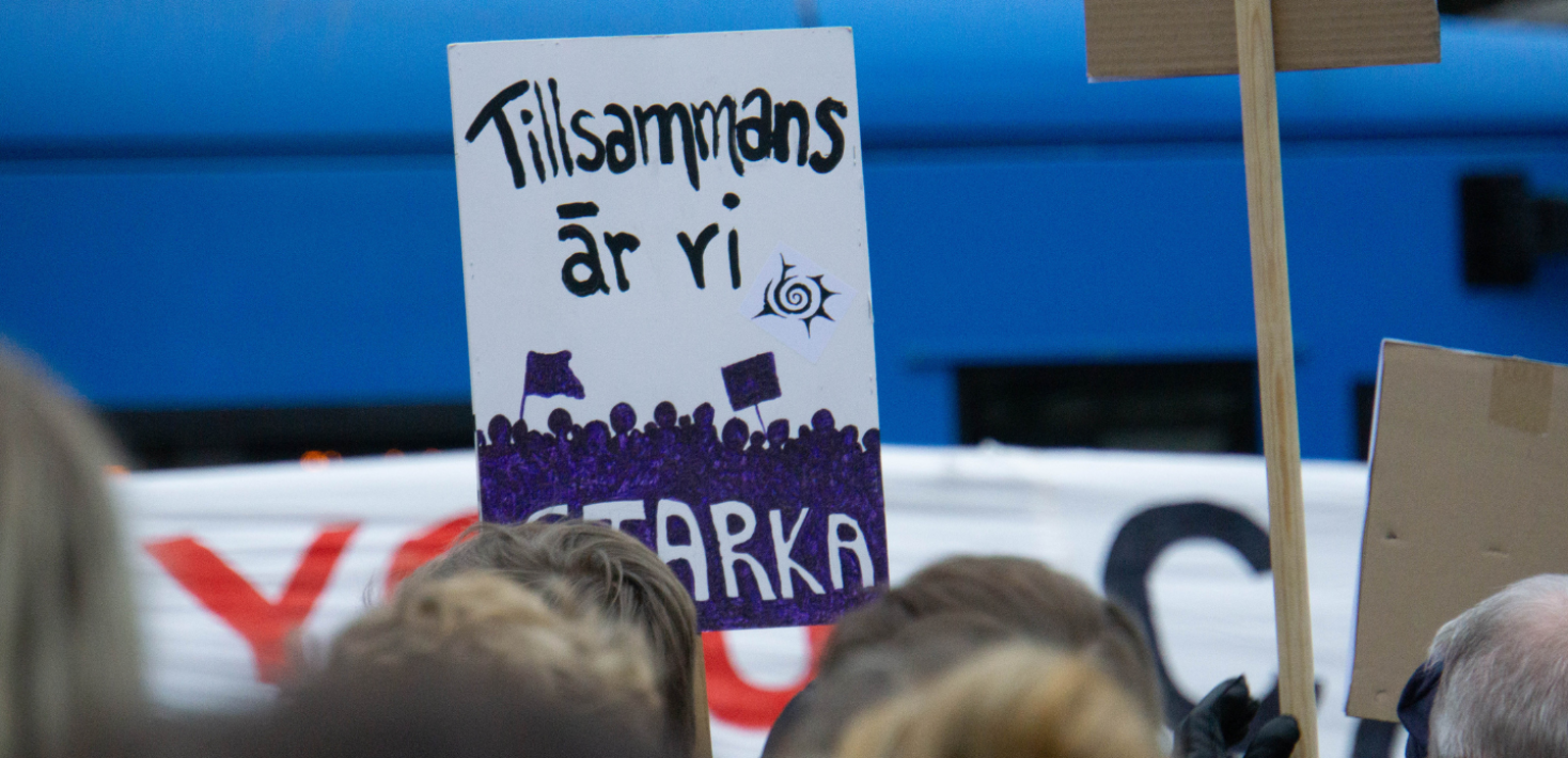 During a rally in Stockholm a protester carries a sign that says "Together, we are strong"