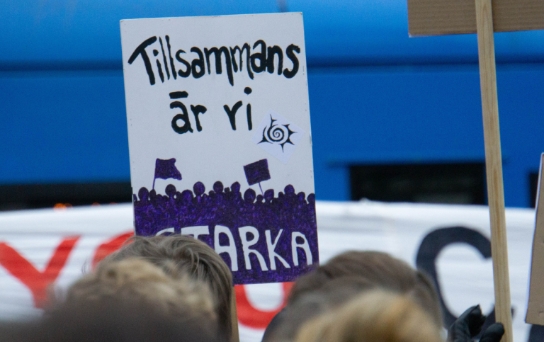 During a rally in Stockholm a protester carries a sign that says "Together, we are strong"