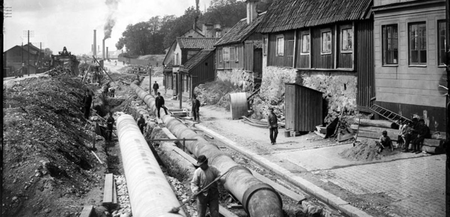 svartvitt fotografi över personer som jobbar med en vattenledning i Stockholm på 1800-talet.